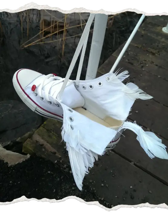 Vit sneaker med vita fjädrar, som ett par vingar